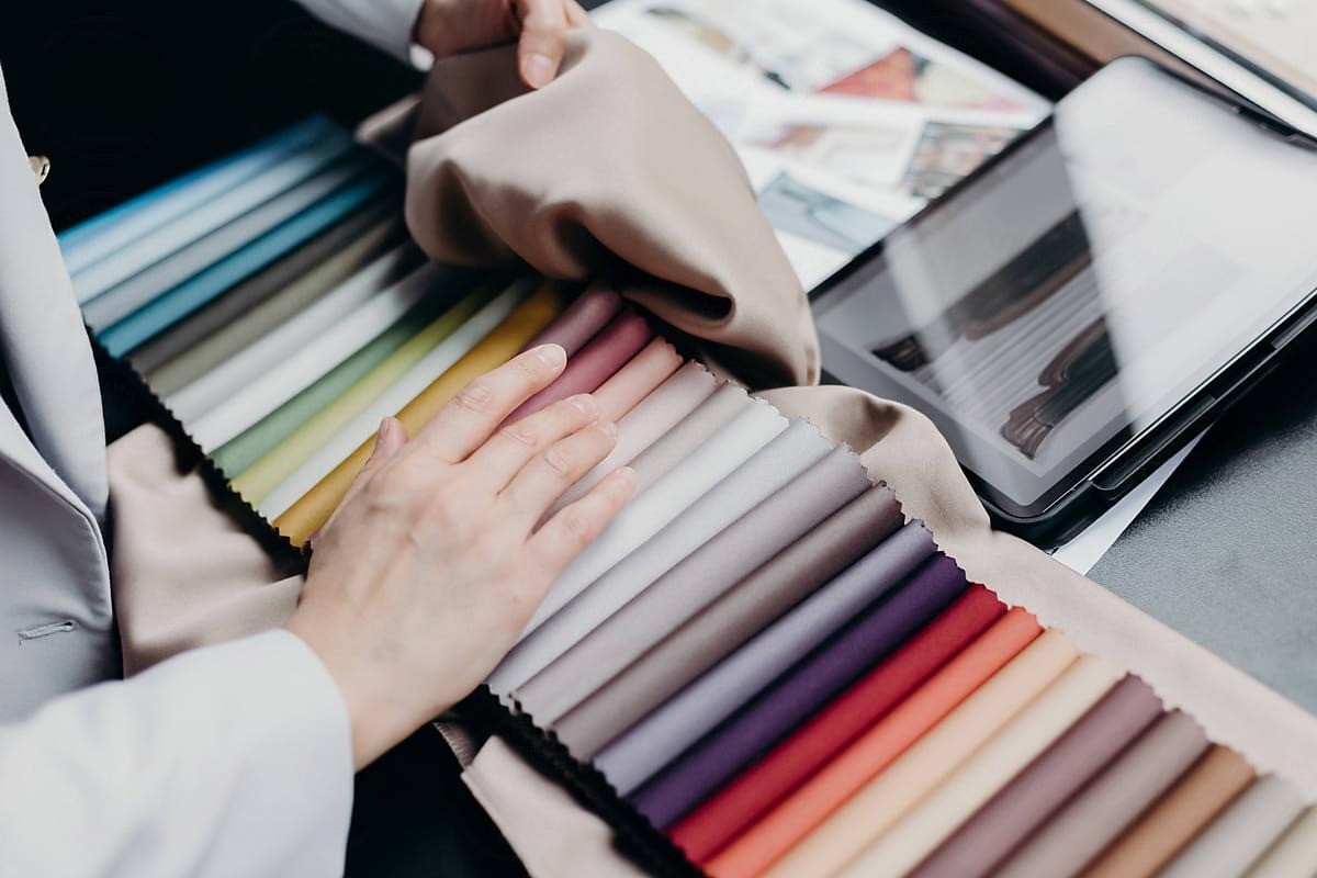 An interior designer reviewing fabric swatches from a sample book